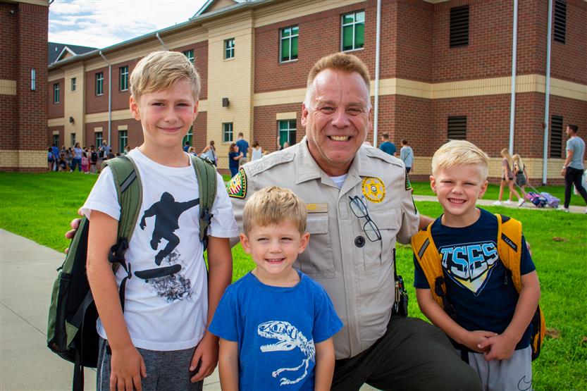 A School Resource Officer smiles with students